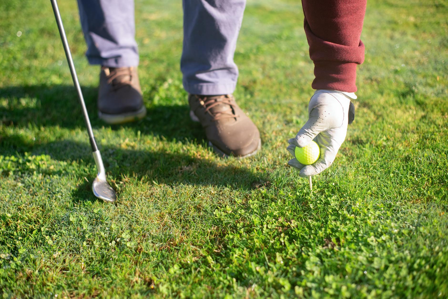 a person putting a golf ball on green grass